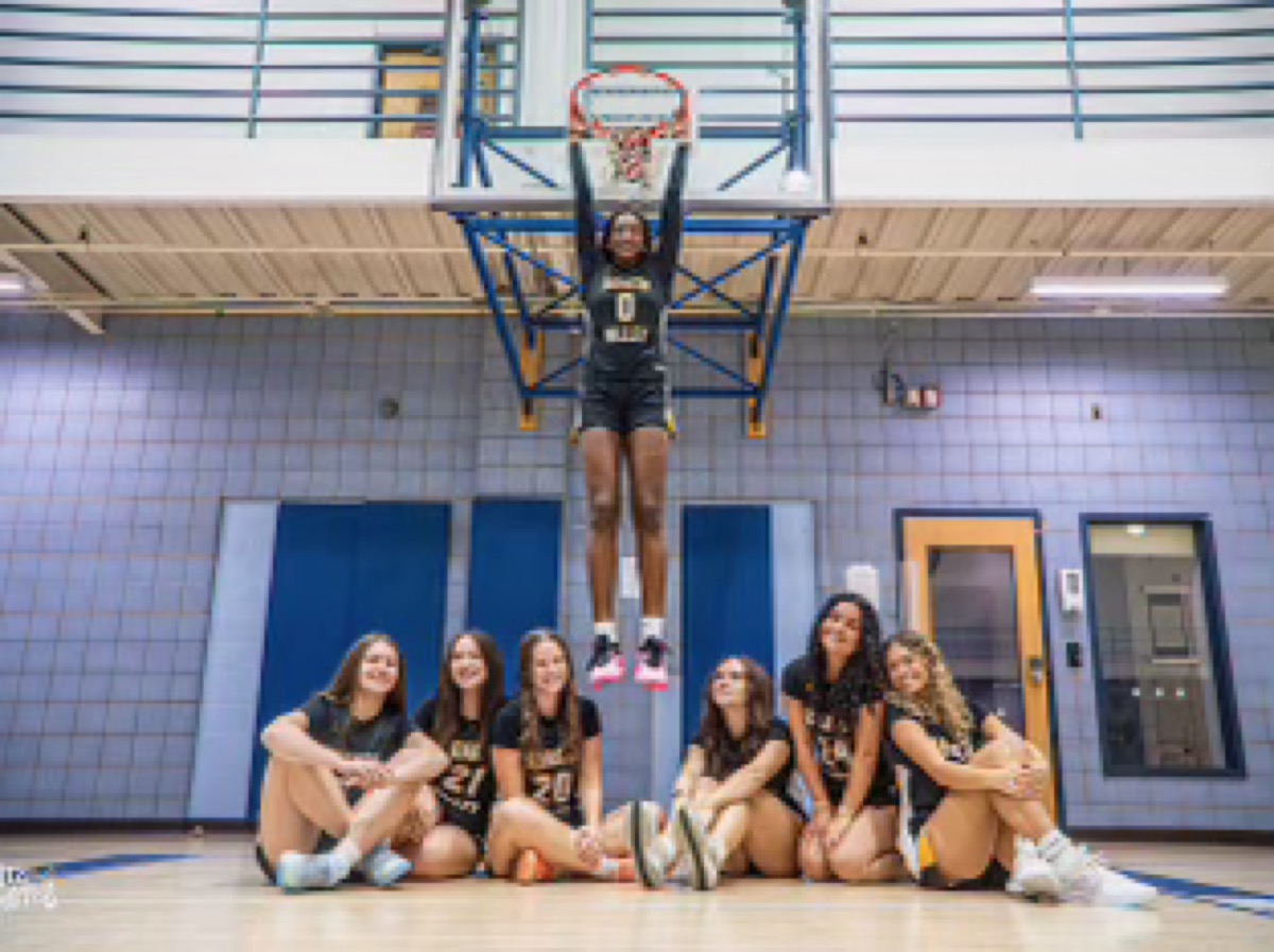 QV team creative photo with Mimi Thiero hanging from the rim