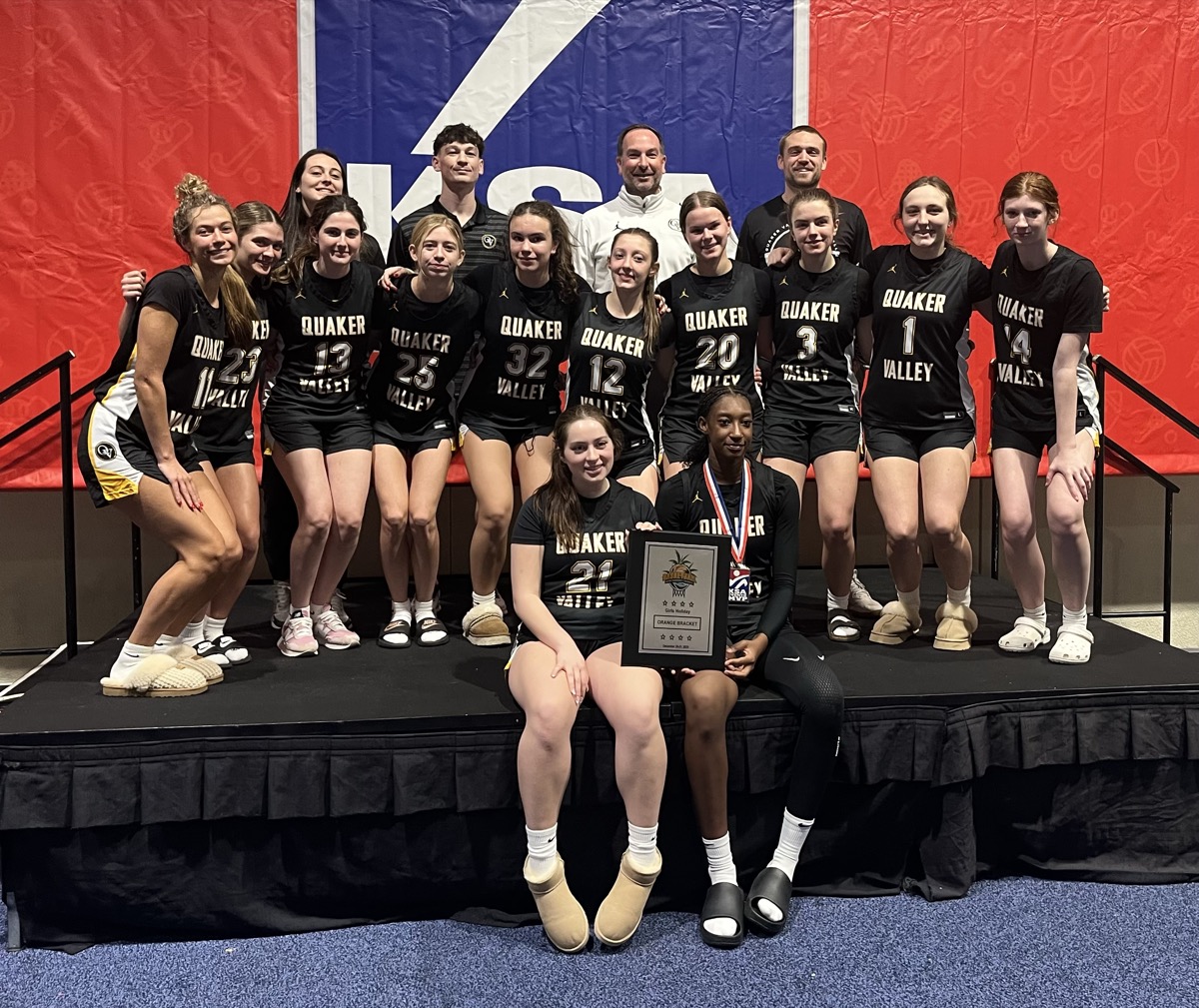 QV Girls Basketball team posing with a plaque at a tournament
